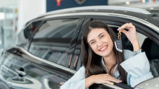 Auto-Leasing fuer junge Erwachsene - junge Frau mit ihrem geleasten Wagen.